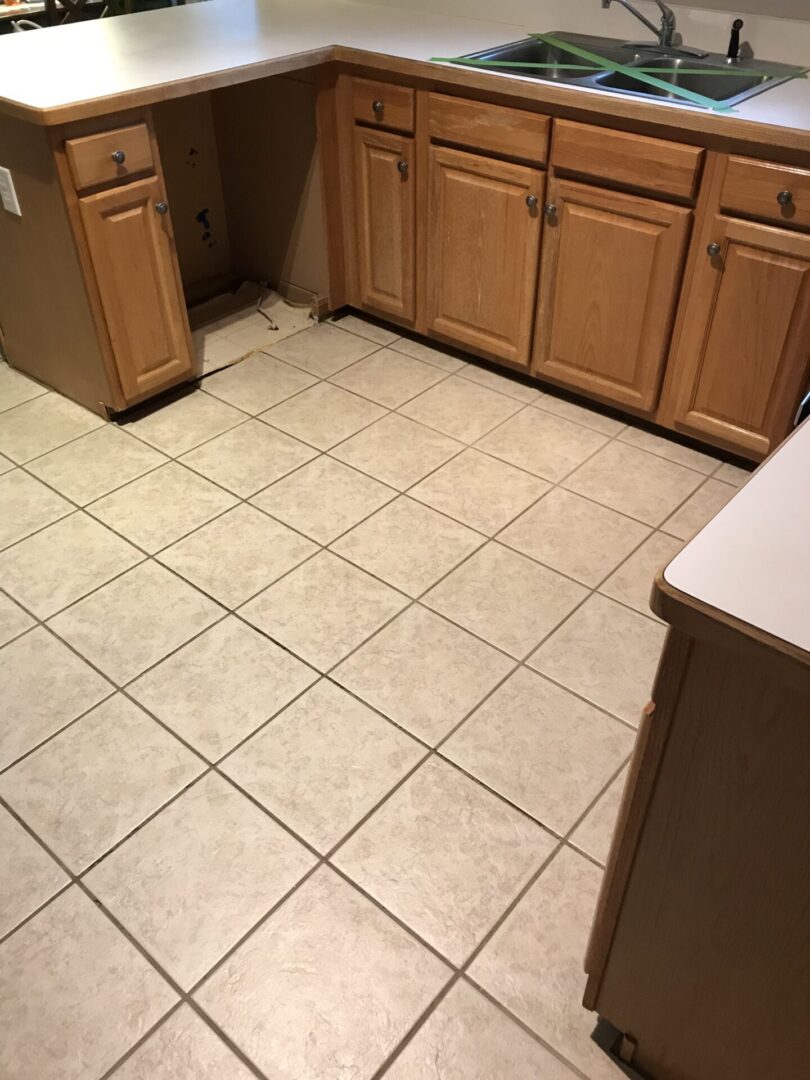 A kitchen with brown tiles and a sink